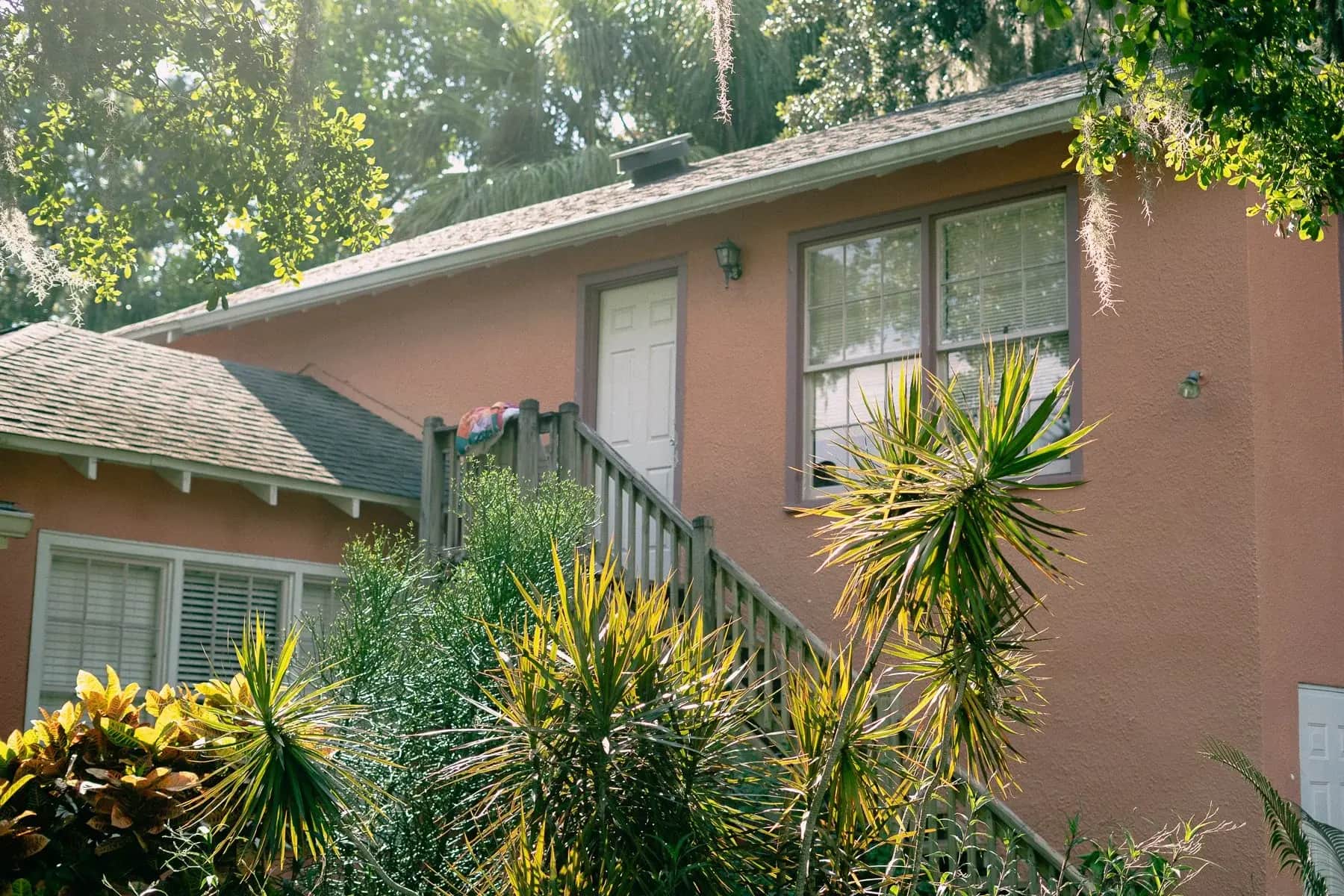 Coral pink Old Florida house under palms and Spanish moss near New Smyrna Beach